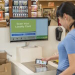 Frau steht an einer Selbstbedienungskasse